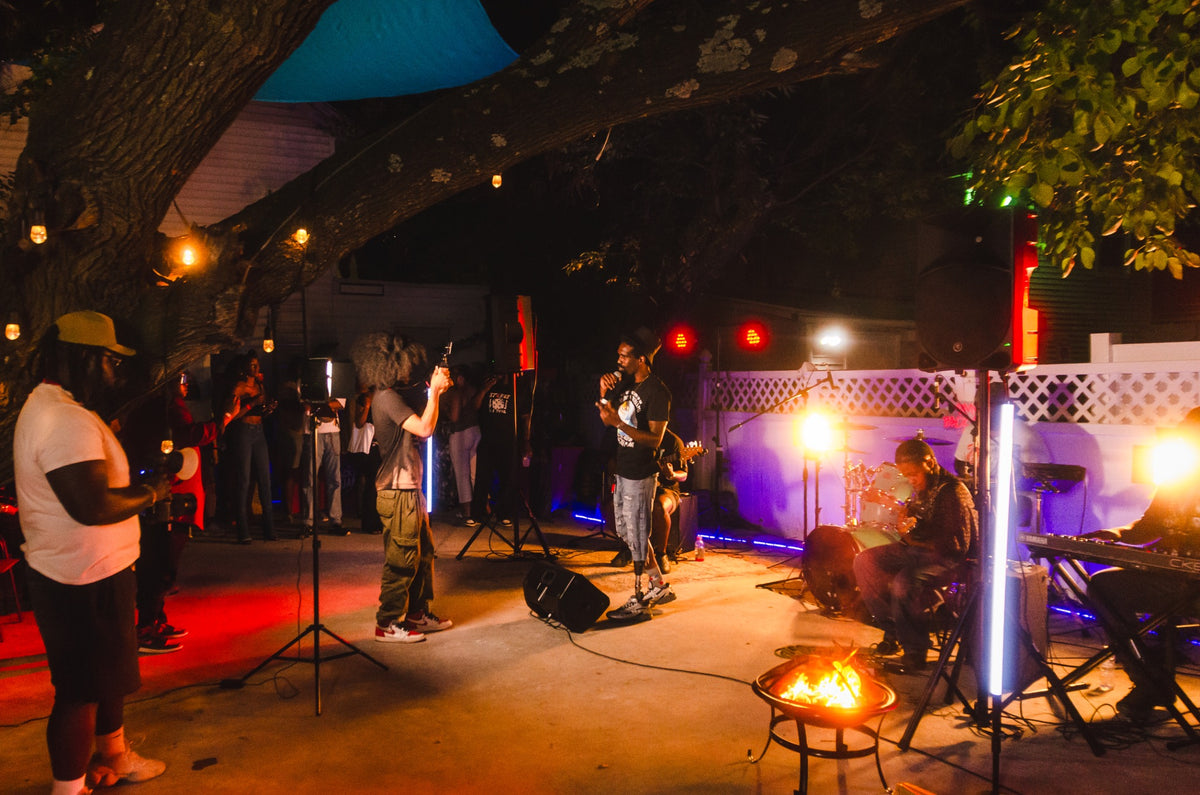 Guests gathered around the fire pit under string lights at DMV Backyard Jam