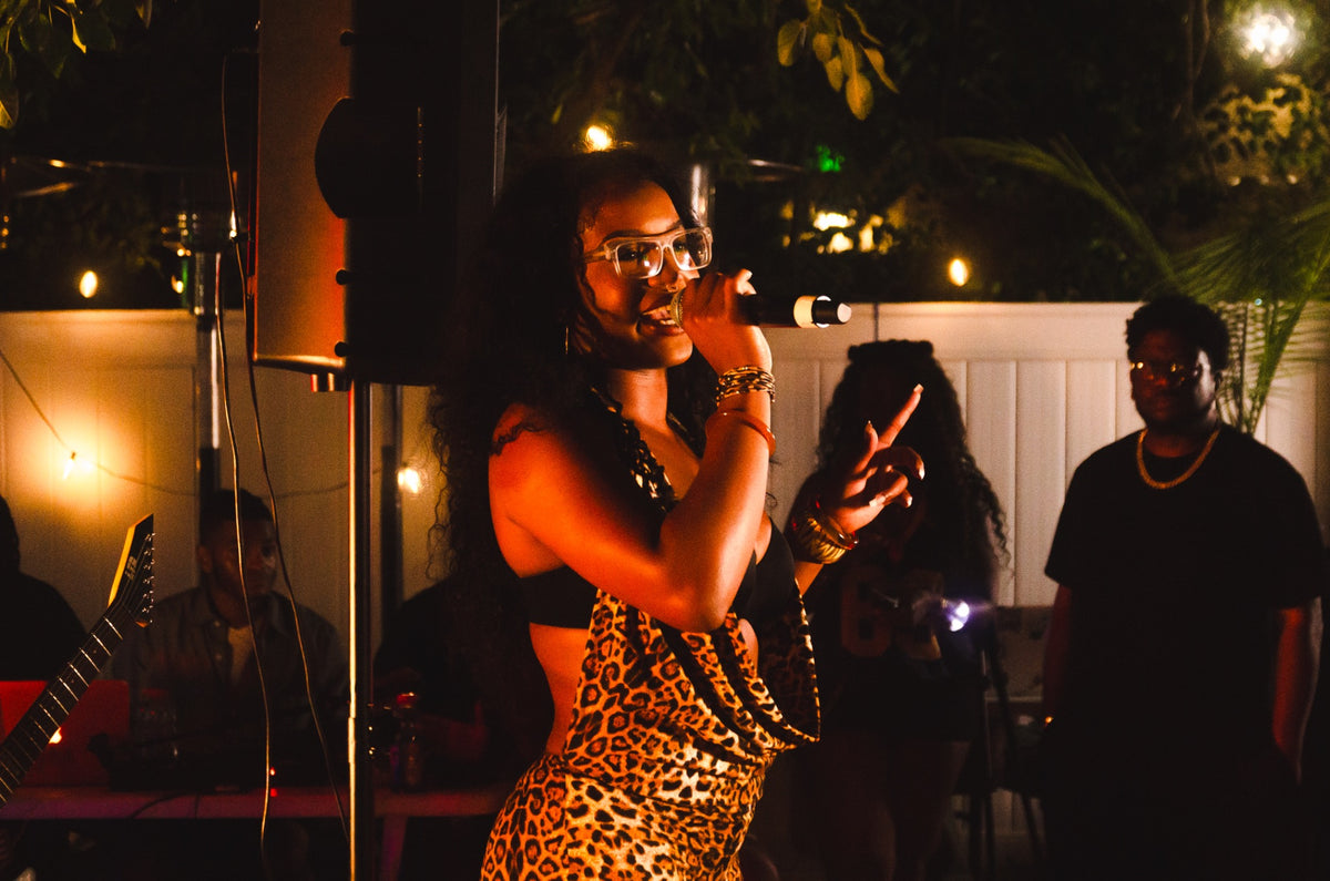 Artist singing into a microphone at DMV Backyard Jam
